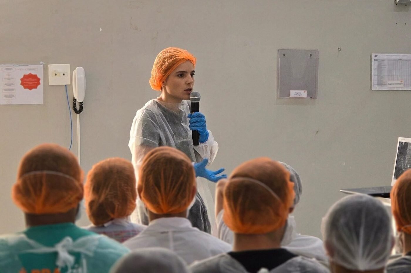 Treinamento ambiental para equipe de produção com touca e jaleco